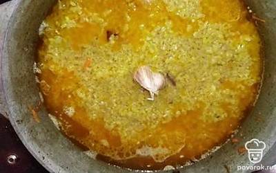 Залейте все сверху водой. В центр вставьте зубки чеснока. Накройте крышкой, оставьте томиться на медленном огне 40 минут.