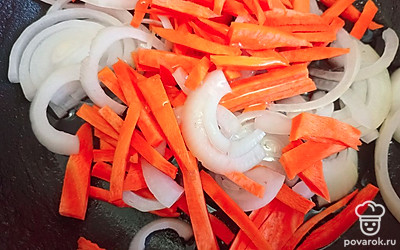 Репчатый лук нарежьте полукольцами. Морковь нарежьте тонкой соломкой. Выложите овощи на сковороду и добавьте растительное масло.