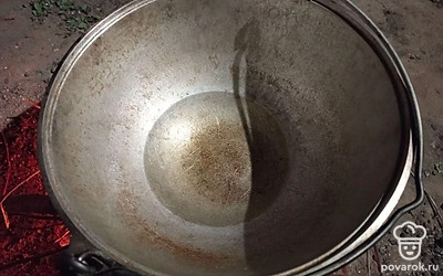 Поставьте казан на костер и налейте в него растительное масло. 