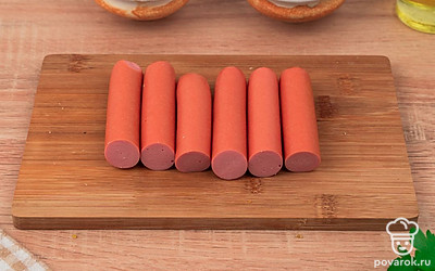 Порежьте сосиски пополам.