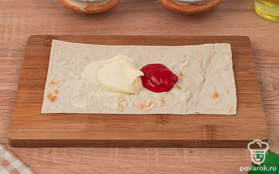 Смажьте каждую часть лаваша ложкой майонеза и кетчупа.