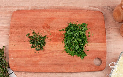 Натрите чеснок на мелкой терке. Порубите петрушку. Отделите листья тимьяна от стеблей.