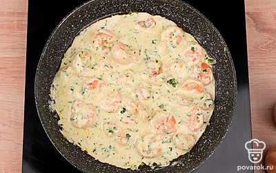 Влейте сливки и перемешайте. Добавьте в соус тертый пармезан. Тушите креветки в соусе 1-2 минуты, пока соус не загустеет.