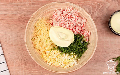 Смешайте яйцо, крабовые палочки, чеснок, зелень и сыр в глубокой миске. Добавьте майонез, соль и перец по вкусу. Тщательно перемешайте ингредиенты до однородности.