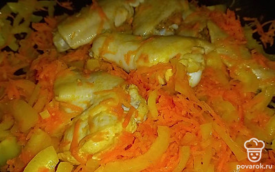 Добавьте в сковороду к крыльям лук и морковь. Жарьте овощи с мясом примерно 10 минут. 