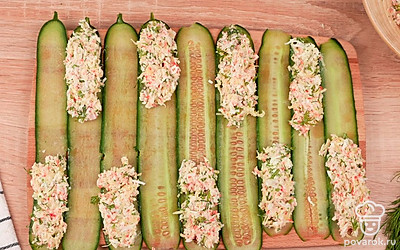 Аккуратно разложите начинку по краешкам слайсов из огурцов. Сверните огурцы с крабовой начинкой в трубочки.