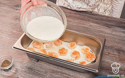 Приготовьте пельмени. Выложите пельмени на противень и положите на них обжаренный лук. Добавьте поверх лука майонезную заправку. Натрите сыр и распределите верхним слоем на противне. Поставьте противень в разогретую до 200 градусов духовку на 30 минут.