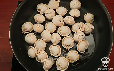 Разогрейте растительное масло на сковороде и обжарьте замороженные пельмени до золотистой корочки.