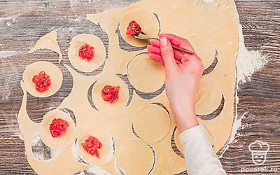 Слепите пельмени. Раскатайте тесто толщиной 2-3 мм. Рюмкой вырежьте кружочки диаметром 4-6 см. Выложите в центр фарш и плотно слепите края теста.