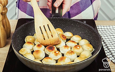 Разогрейте сковороду и растопите на ней растительное масло. Выложите пельмени в сковороду. Обжарьте пельмени до золотистой корочки в течении 5–7 минут на среднем огне, а затем убавьте газ, поштучно переверните пельмени и смажьте их сливочным маслом.