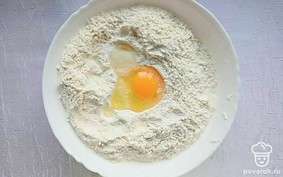 Высыпьте в миску муку и добавьте яйцо и соль, размешайте вилкой и постепенно добавляйте теплую воду и вымешивайте. Тесто должно быть однородным и упругим, заверните его в пленку и оставьте отдохнуть примерно на 30 минут.