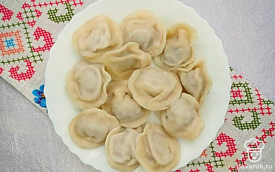 Готовые пельмени подавайте порционно, украсив сметаной и зеленью, это отличное вкусовое сочетание, проверенное годами.