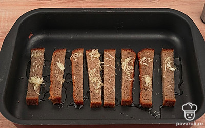 Выложите хлеб на противень, полейте чесночным маслом и посолите.