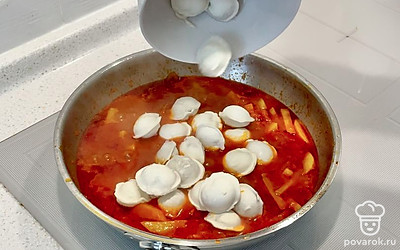 Добавьте к луку и чесноку две столовые ложки томатной пасты и картофель, обжаривайте 15 минут. Затем добавьте тертую на средней терке морковь, долейте 2 стакана воды, кипятите все 5 минут. После этого закиньте пельмени, накройте крышкой и варите 7 минут.