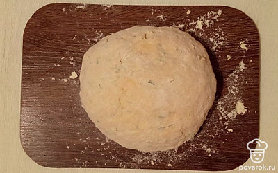 В настоявшееся тесто добавьте измельченный укроп и муку и вымешивайте все руками, пока масса не перестанет прилипать к рукам. Получившееся тесто накройте пищевой пленкой и поставьте отдыхать еще на 25 минут.