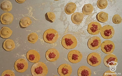 Настоявшееся тесто раскатайте в пласт толщиной около 2-3 мм, рюмкой вырежьте в нем круги. В центр каждой заготовки поместите немного начинки и сформируйте пельмени. Варите их в подсоленной кипящей воде 5 минут.