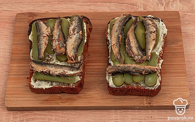 Сверху на огурцы выложите шпроты.