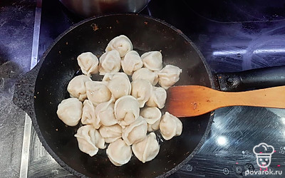 Выложите полуготовые пельмени на сковороду. Жарьте, переворачивая, 7 минут до золотистой корочки.