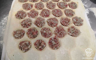 Положите пласт теста на пельменницу, разложите фарш и сверху закройте другим пластом теста. Раскатайте скалкой. 