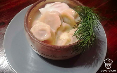 Готовые пельмени можно подавать со сметаной и сливочным маслом, украсив веточкой зелени. 