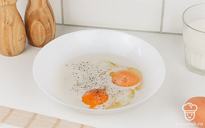 В миске смешайте яйца и молоко. Добавьте соль и черный перец.