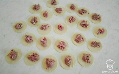 Тесто разделите на две части, раскатайте круг. Вырежьте стаканом или другим приспособлением кружочки. В центр кружочка выложите немного фарша, сложите кружочек вместе и защипните края.