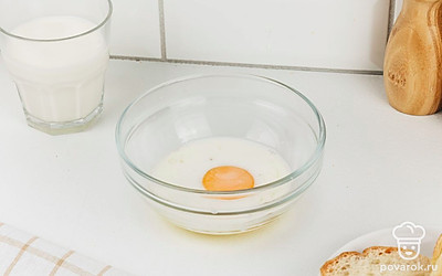 В миску разбейте куриное яйцо и влейте молоко. Посолите и поперчите по вкусу.