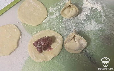 Положить фарш в кружочки теста и слепить пельмени ушки.