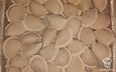 В смазанную маслом форму выложить замороженные пельмени в один слой.