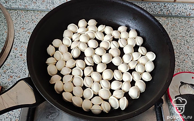 Разогреваем сковороду с маслом. Выкладываем замороженные пельмени. У меня маленькие, и все время приготовления рассчитано на маленькие пельмени. Обжариваем 5 минут.