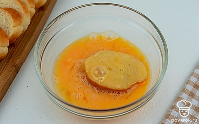 Каждый ломтик багета опустите в миску с яйцами и дате немного пропитаться обеим сторонам хлеба.