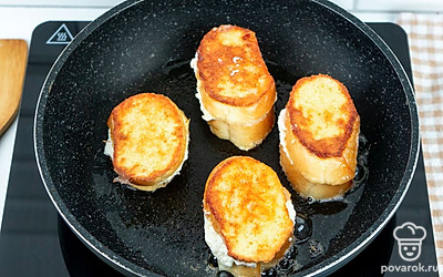 Когда одна сторона гренок подрумянится, переверните на другую и жарьте без крышки еще около 4 минут.