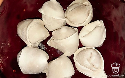 На дно горшочка выложить слой пельменей.