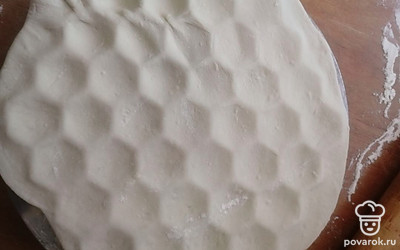 Распределяем раскатанный пласт на пельменнице. Сразу же раскатываем второй пласт. Им будем накрывать сверху. 