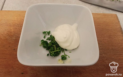 Петрушку порежьте и смешайте с чесноком и сметаной.