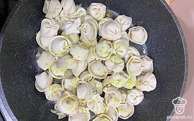 Открываем крышку, добавляем чесночный перец, чеснок и перемешиваем пельмешки. Оставляем крышку открытой.