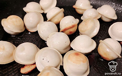 Добавьте в сковороду пельмени и жарьте на среднем огне до готовности, периодически помешивая.