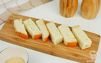 Нарежьте белый хлеб небольшими брусочками шириной 1 см.