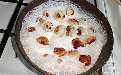 Добавьте к пельменям сливки, посолите по вкусу, тушите на слабом огне 3-4 минуты.