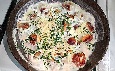 В конце приготовления добавьте свежую зелень. Подавайте пельмени в сливках горячими.