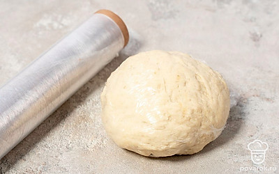 Постепенно всыпьте в яйцо муку. Тщательно перемешайте до однородной консистенции. Замесите тесто руками. Слепите из него шар и оберните его пищевой пленкой. Оставьте тесто на 10 минут.