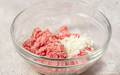 Выложите фарш в отдельную миску. Мелко нарежьте лук, половину добавьте к фаршу.