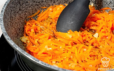 Разогрейте в сковороде масло. Натрите морковь и обжарьте на раскаленном масле вместе с оставшейся половиной лука в течение 3-4 минут.