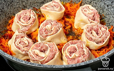 На обжаренные овощи выложите ленивые пельмени. Снова поставьте сковороду на огонь. Влейте воду и готовьте блюдо под крышкой около 20 минут.