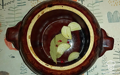 На дно горшочка положите лавровый лист, чеснок, разрезаный на две части, розовый перец горошком.