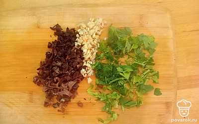 Пока варятся пельмени, подготовьте овощи. Мелко нарежьте грибы, чеснок и зелень.