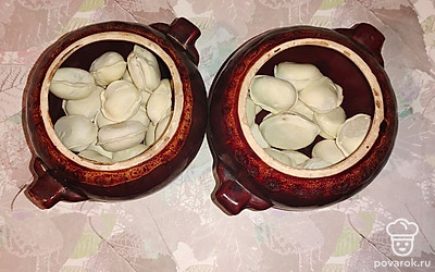 Замороженные пельмени выложите в горшочки.