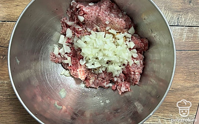 К фаршу добавьте нарезанный кубиком лук и сушеный чеснок. Посолите и поперчите по вкусу.