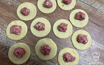 На кружки теста выложите фарш (примерно 1 чайную ложку без горки).