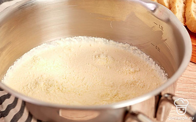 Приготовьте соус. Вино вылейте в сотейник и выпарите его на среднем огне в течение 2 минут. Добавьте половину сливок, перемешайте. Другую половину сливок слегка взбейте с желтком и, тонкой струйкой, постоянно помешивая венчиком, влейте к вину. Добавьте соль и тертый сыр. Хорошо перемешайте, снимите с огня и дайте немного остыть.